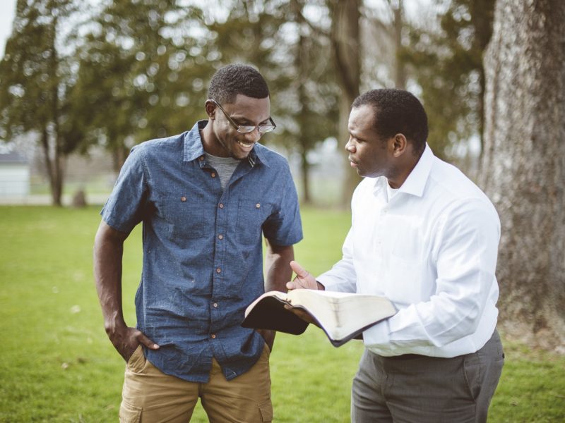 african-american-male-friends-standing-park-discussing-bible (1)